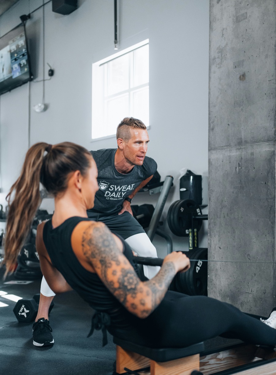 Coach and client mid-workout in a gym